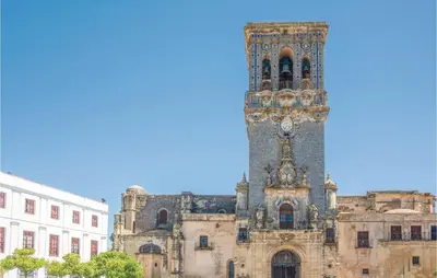 a building with a tower with a clock on it at Nice Home In Arcos De La Frontera in Arcos de la Frontera