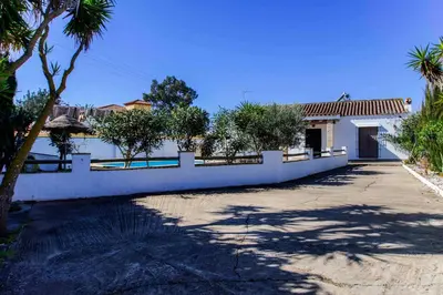 a house with a white fence and a driveway at Vivienda Rural Atlántico Sur & Familias in Conil de la Frontera