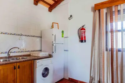 a kitchen with a refrigerator and a washing machine at Vivienda Rural Atlántico Sur & Familias in Conil de la Frontera