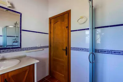 a bathroom with a shower and a wooden door at Vivienda Rural Atlántico Sur & Familias in Conil de la Frontera