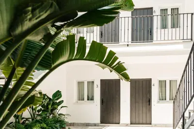 a living room with a couch and a kitchen at ASTUTO 21 Suites - Adults Only in Jerez de la Frontera