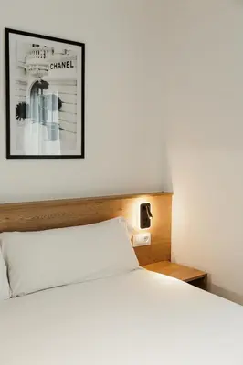 a large white bed with a purse on top of it at ASTUTO 21 Suites - Adults Only in Jerez de la Frontera