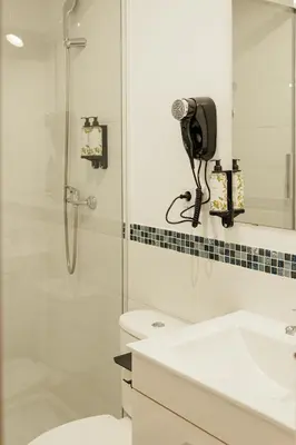a bathroom with a toilet and a sink and a shower at ASTUTO 21 Suites - Adults Only in Jerez de la Frontera