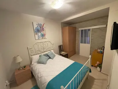 a bedroom with a white bed with blue pillows at Palast Stieg Guest House in Jerez de la Frontera