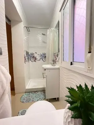 a white bathroom with a tub and a sink at Palast Stieg Guest House in Jerez de la Frontera