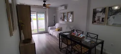 a living room with a white couch and a table at Apto Melkart in Chiclana de la Frontera