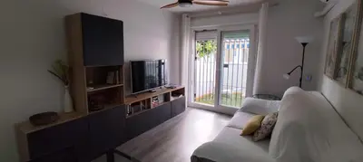 a living room with a couch and a tv at Apto Melkart in Chiclana de la Frontera