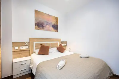 a bedroom with a bed and a painting on the wall at Casa Plotina Pompeya in Cádiz