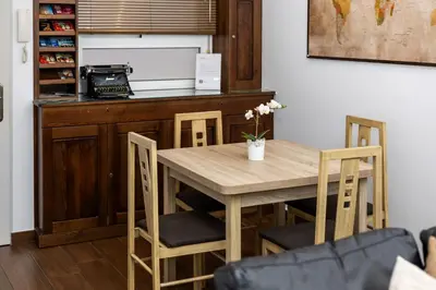 a kitchen with a wooden table and chairs at Casa Plotina Pompeya in Cádiz