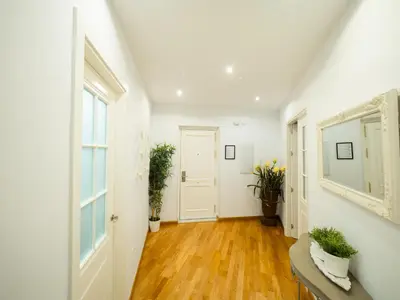 a hallway with white walls and wooden floors and a window at Amplio Apto Centro vistas Torneria fjhomefj in Jerez de la Frontera