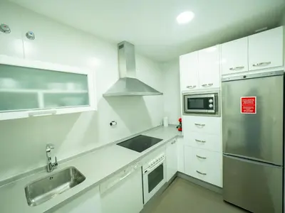 a kitchen with white cabinets and a stainless steel refrigerator at Amplio Apto Centro vistas Torneria fjhomefj in Jerez de la Frontera
