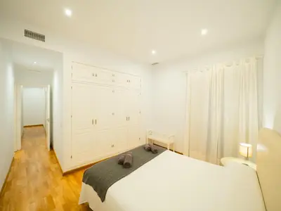 a white bedroom with a large bed and a window at Amplio Apto Centro vistas Torneria fjhomefj in Jerez de la Frontera