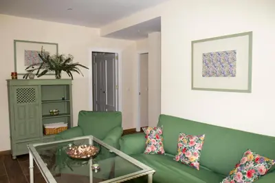 a living room with a green couch and a glass table at Infanta Beatriz in Sanlúcar de Barrameda