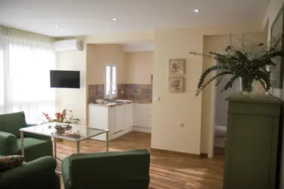 a living room with a table and a kitchen at Infanta Beatriz in Sanlúcar de Barrameda