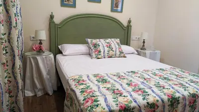 a bedroom with a bed with a green headboard at Infanta Beatriz in Sanlúcar de Barrameda