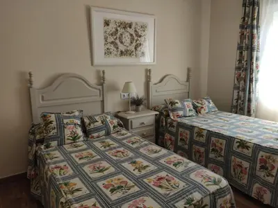 a bedroom with two beds and a night stand at Infanta Beatriz in Sanlúcar de Barrameda