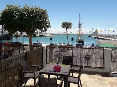 a table and chairs with a view of a marina at Apartamento faro Puerto Sherry in El Puerto de Santa María