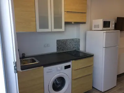 a kitchen with a white refrigerator and a washing machine at Apartamento faro Puerto Sherry in El Puerto de Santa María