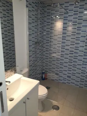 a bathroom with a toilet and a glass shower at Apartamento faro Puerto Sherry in El Puerto de Santa María