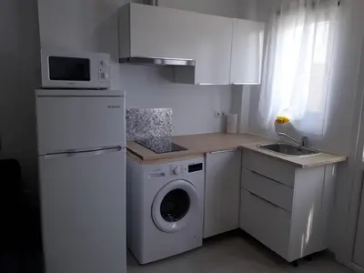 a kitchen with a washing machine and a microwave at Apartamento faro Puerto Sherry in El Puerto de Santa María
