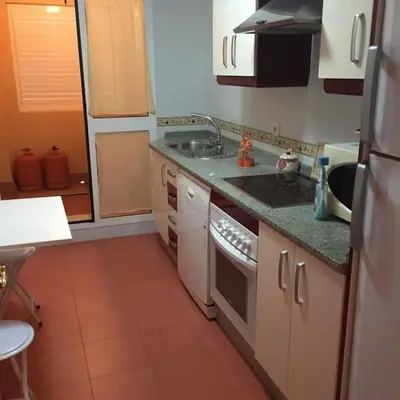 a small kitchen with a sink and a stove at Playa de Las Piletas in Sanlúcar de Barrameda