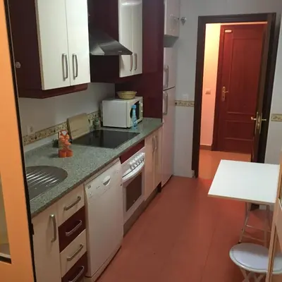 a small kitchen with a sink and a microwave at Playa de Las Piletas in Sanlúcar de Barrameda