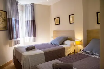 a hotel room with two beds and a window at LOS INFANTES 7-5-24 in Sanlúcar de Barrameda
