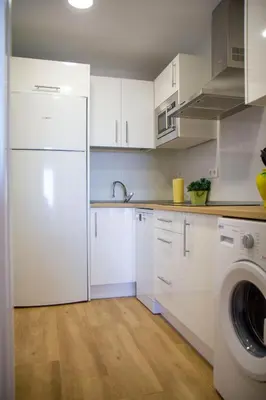 a kitchen with white cabinets and a washing machine at LOS INFANTES 7-5-24 in Sanlúcar de Barrameda