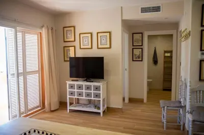 a living room with a flat screen tv on a white cabinet at LOS INFANTES 7-5-24 in Sanlúcar de Barrameda