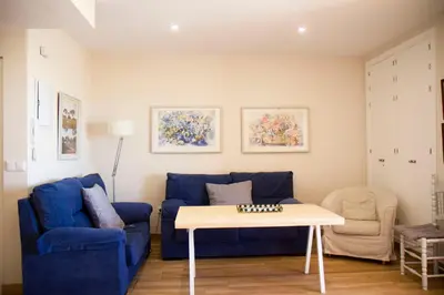 a living room with a blue couch and a table at LOS INFANTES 7-5-24 in Sanlúcar de Barrameda