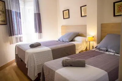 a hotel room with two beds and a window at LOS INFANTES 7-5-24 in Sanlúcar de Barrameda