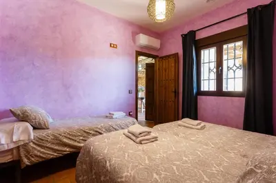 two beds in a room with pink walls at El Castillito in Chiclana de la Frontera
