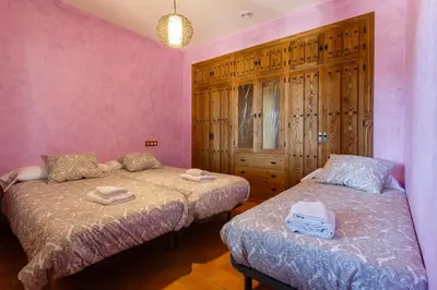 two beds in a room with pink walls at El Castillito in Chiclana de la Frontera
