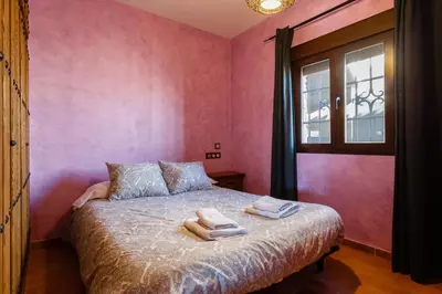 a bedroom with pink walls and a bed with towels on it at El Castillito in Chiclana de la Frontera
