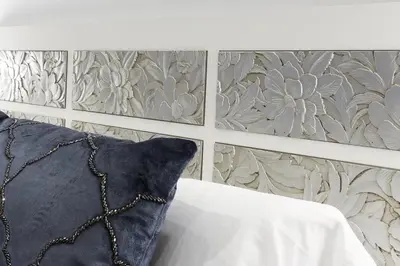 a bedroom with a pillow and a wall with flowers at Little LIBERTAD Heart of Cadiz Grupo AC Gestion in Cádiz