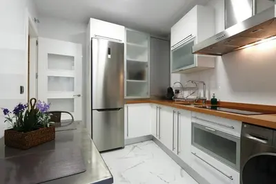 a kitchen with white cabinets and a stainless steel refrigerator at Little LIBERTAD Heart of Cadiz Grupo AC Gestion in Cádiz