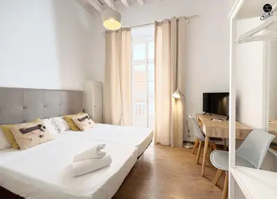 a white bedroom with a bed and a desk at Posada Flamenco Grupo AC Gestion in Cádiz