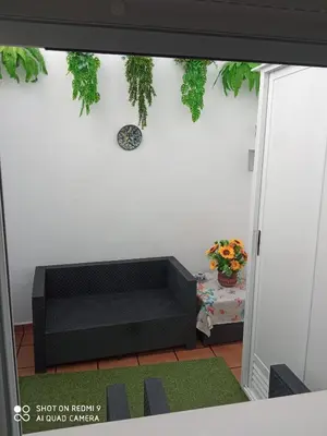 a living room with a black couch against a wall at Apartamento Solis in Chipiona