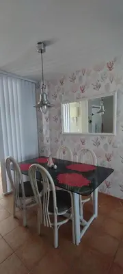 a dining room table with chairs and a mirror at Frente al mar in Rota