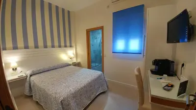a small bedroom with a bed and a television at Hostal Paris in San Fernando