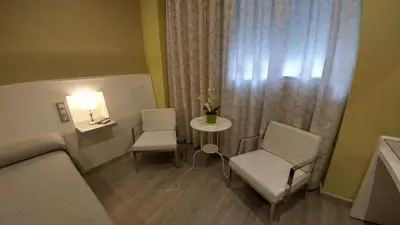 a room with a bed and a table and chairs at Hostal Paris in San Fernando