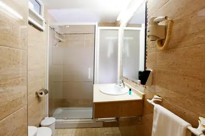 a bathroom with a sink and a toilet and a shower at Hostal Paris in San Fernando