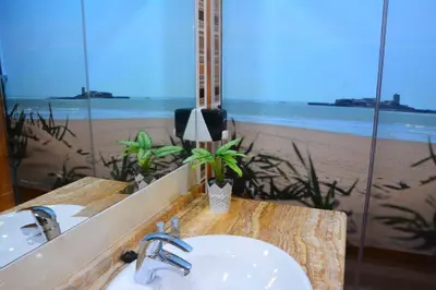 a bathroom with a sink and a view of the beach at Hostal Paris in San Fernando