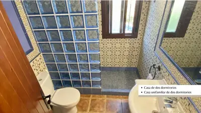 a bathroom with a toilet and a shower with blue tiles at Arco Casas Adosadas in Conil de la Frontera