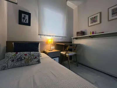 a bedroom with a bed and a table with a lamp at Apartamento en la playa de Valdelagrana in El Puerto de Santa María