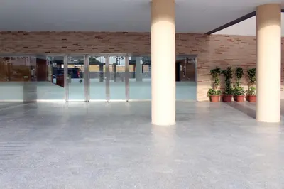 an empty lobby of a building with columns and potted plants at Apartamento en la playa de Valdelagrana in El Puerto de Santa María