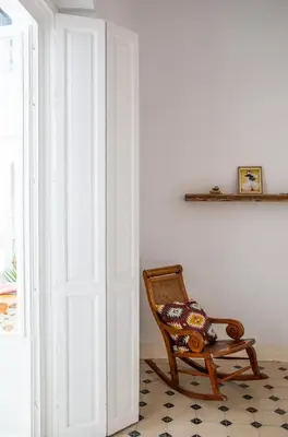 a wooden rocking chair sitting next to a door at Casa Plaza San Antonio in Cádiz