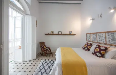 a bedroom with a bed with a yellow blanket at Casa Plaza San Antonio in Cádiz