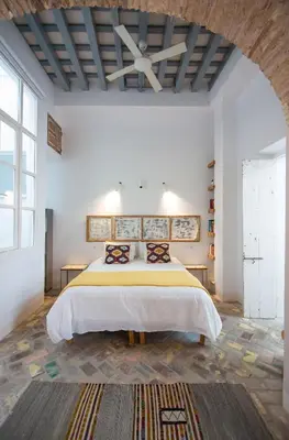 a bedroom with a large bed in a white room at Casa Plaza San Antonio in Cádiz
