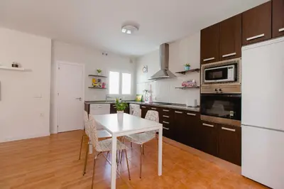 a kitchen with a white table and a white refrigerator at Atico Centro Historico in Cádiz